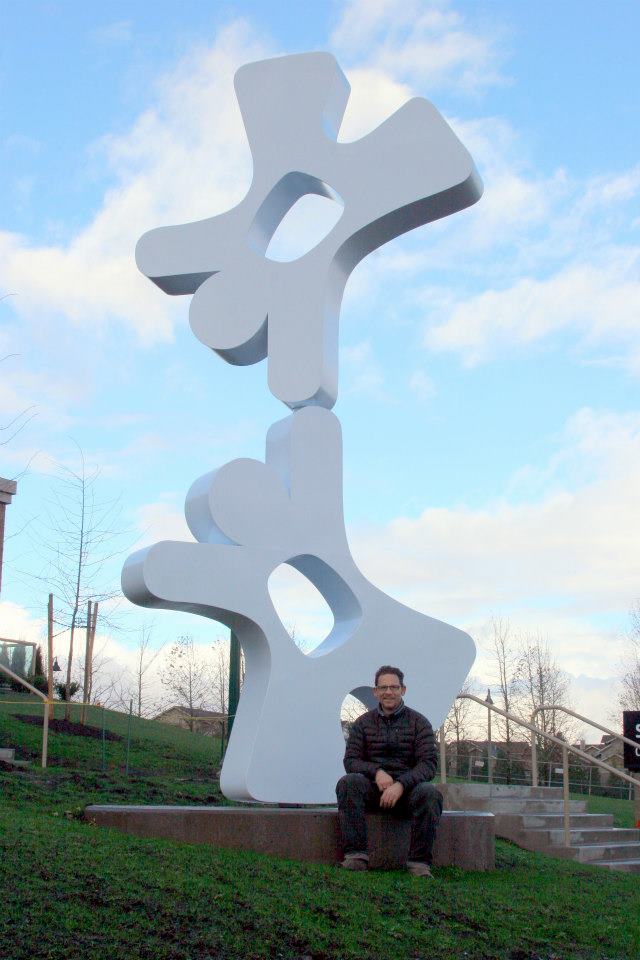 Artist CJ Rench with his sculpture Happy Humans
